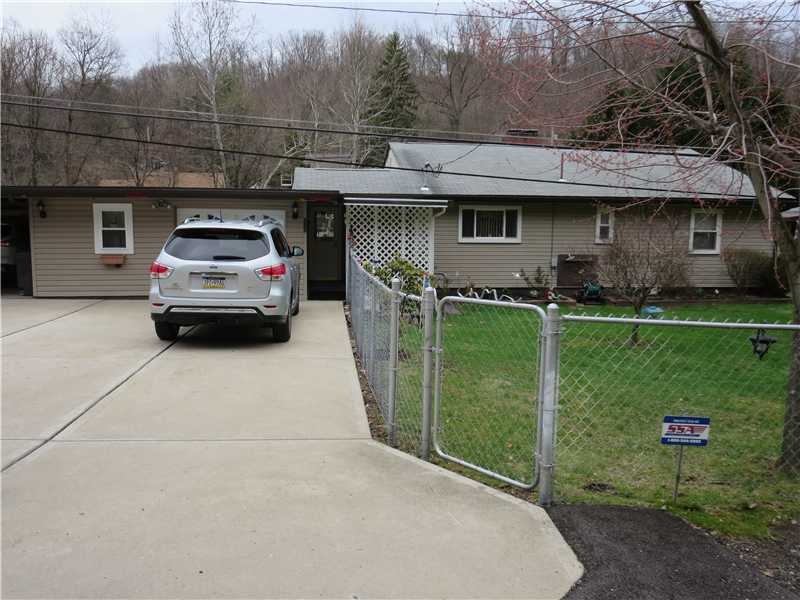 Exterior Front. Partially fenced yard.  Concrete D