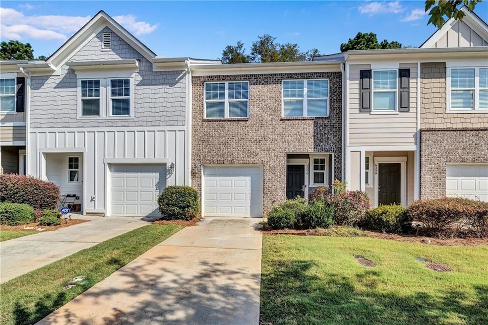 View of front of home with board and batten siding, driveway, a front lawn, and brick siding