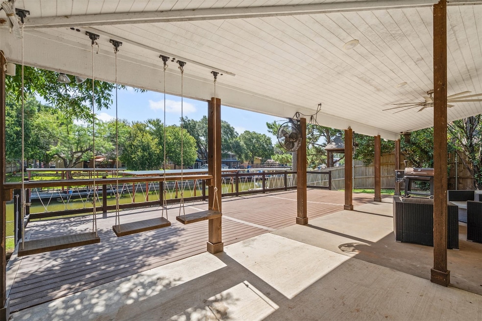Fenced backyard with a water view, a patio, and a ceiling fan