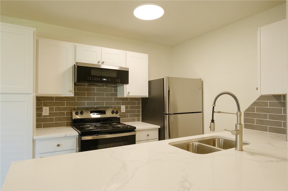 Kitchen with a sink, light stone countertops, deco