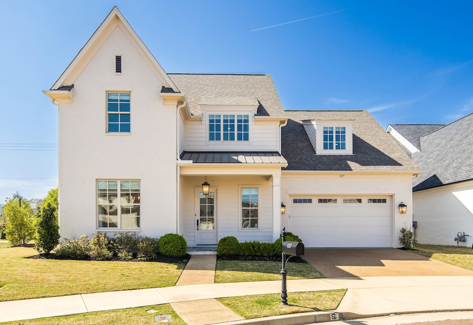 View of front facade with an attached garage, a st