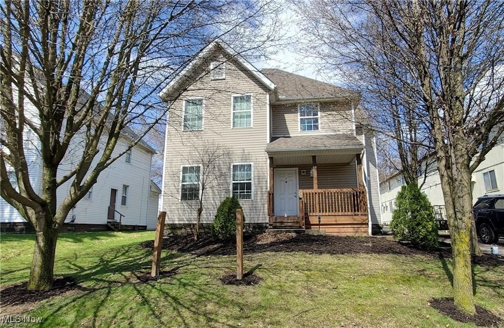 Traditional-style house featuring a front yard, covered porch, and a shingled roof
