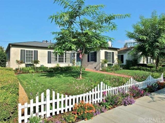 Exterior with custom fence and landscaping.