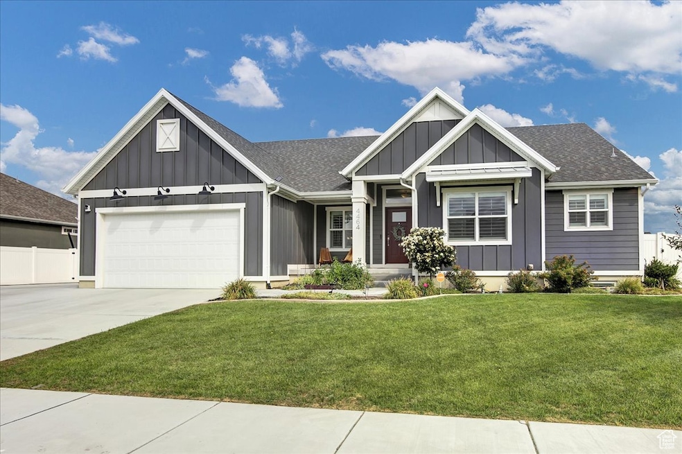 View of front of property with board and batten siding, concrete driveway, an attached garage, and roof with shingles