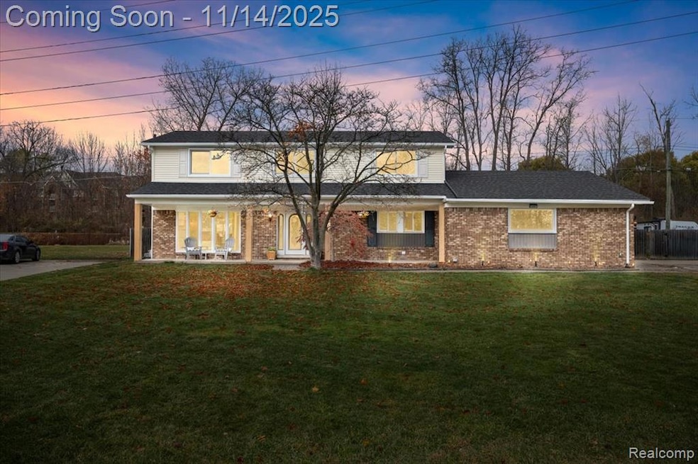 Traditional-style house with a front yard, brick siding, a porch, and roof with shingles
