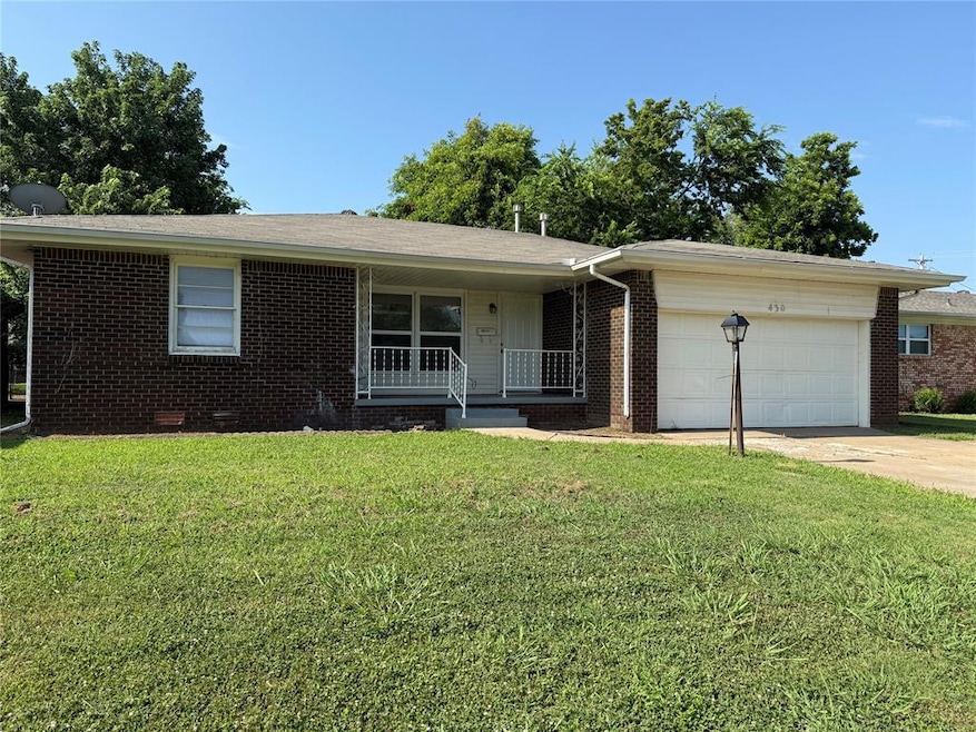 Single story home with a porch, an attached garage, concrete driveway, brick siding, and a front yard