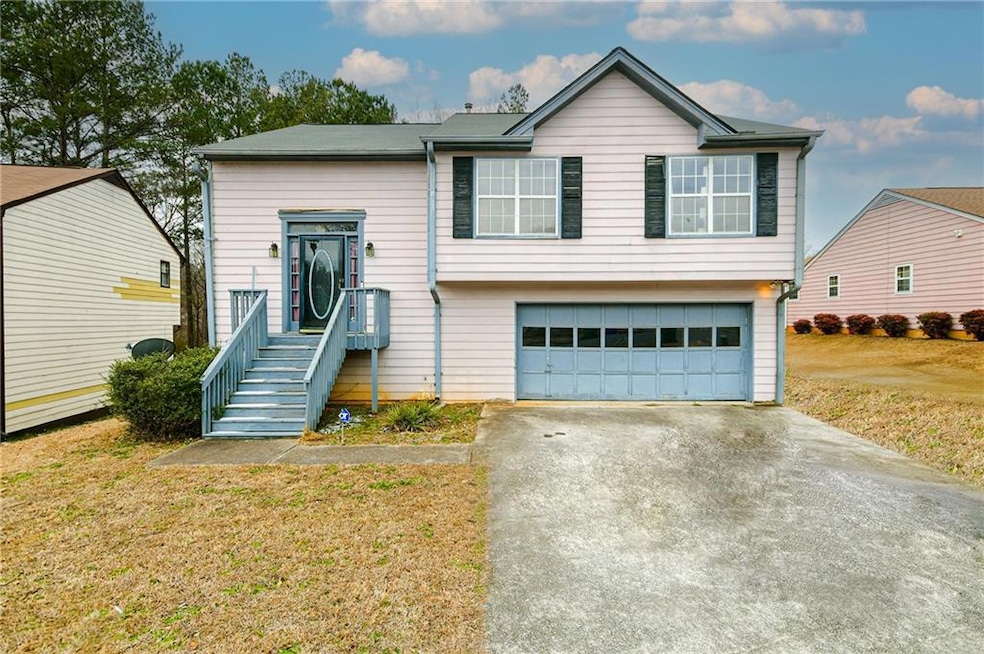 Split foyer home featuring a garage and a front ya