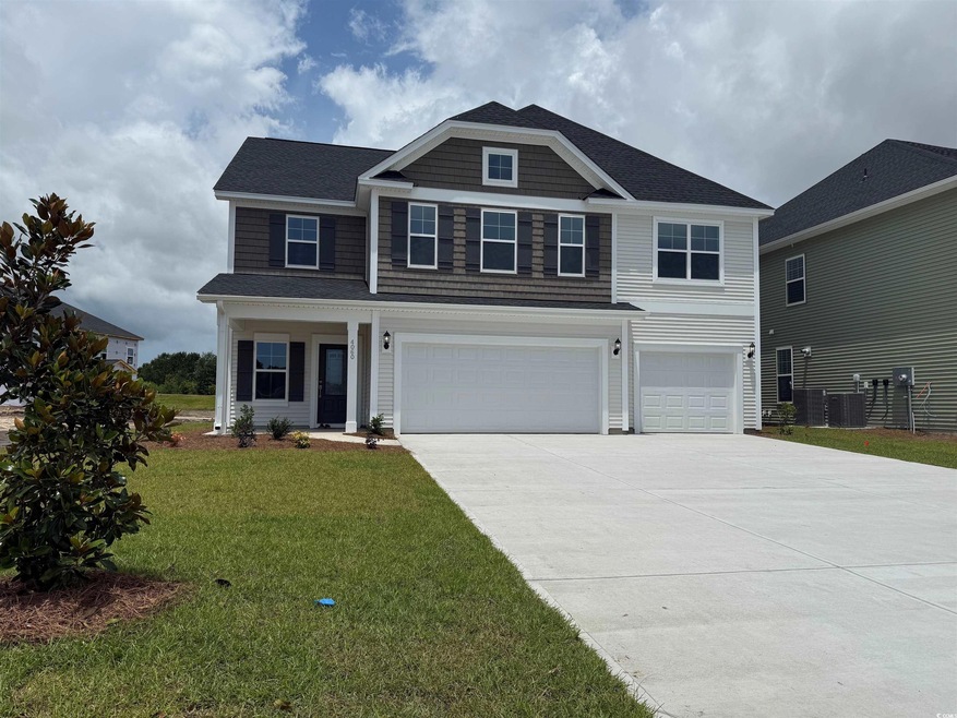 View of front of property with an attached garage, driveway, a front lawn, and roof with shingles