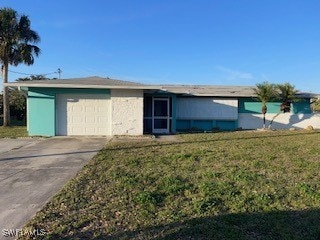 Single story home featuring a garage and a front y