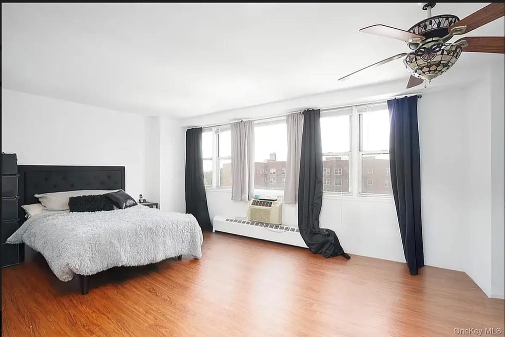 Bedroom featuring light wood-type flooring and a baseboard radiator