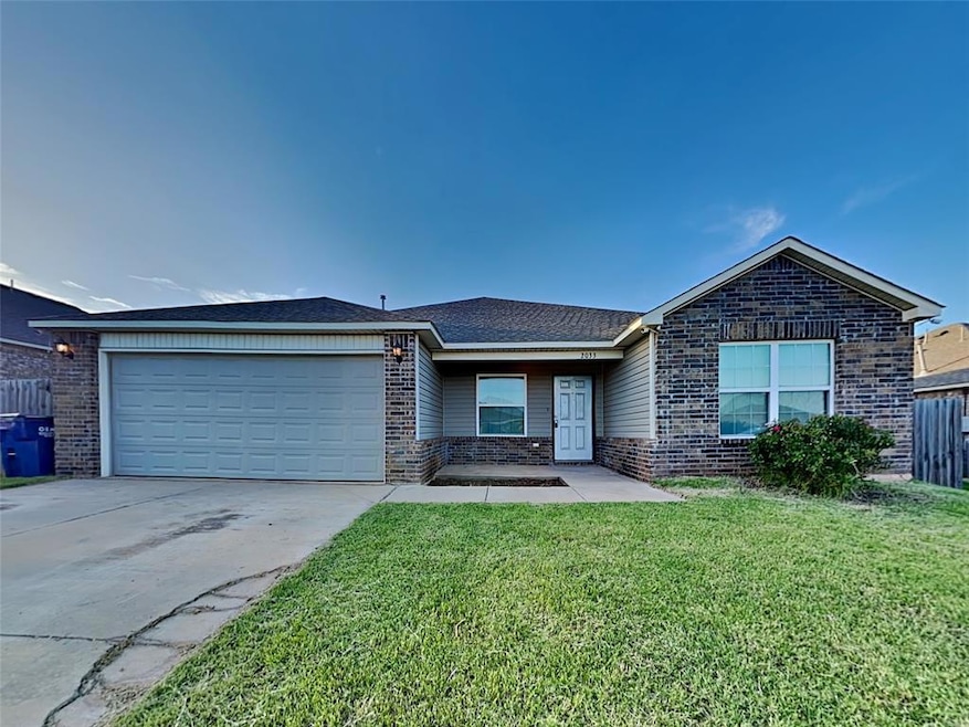 Single story home featuring brick siding, driveway, and a garage