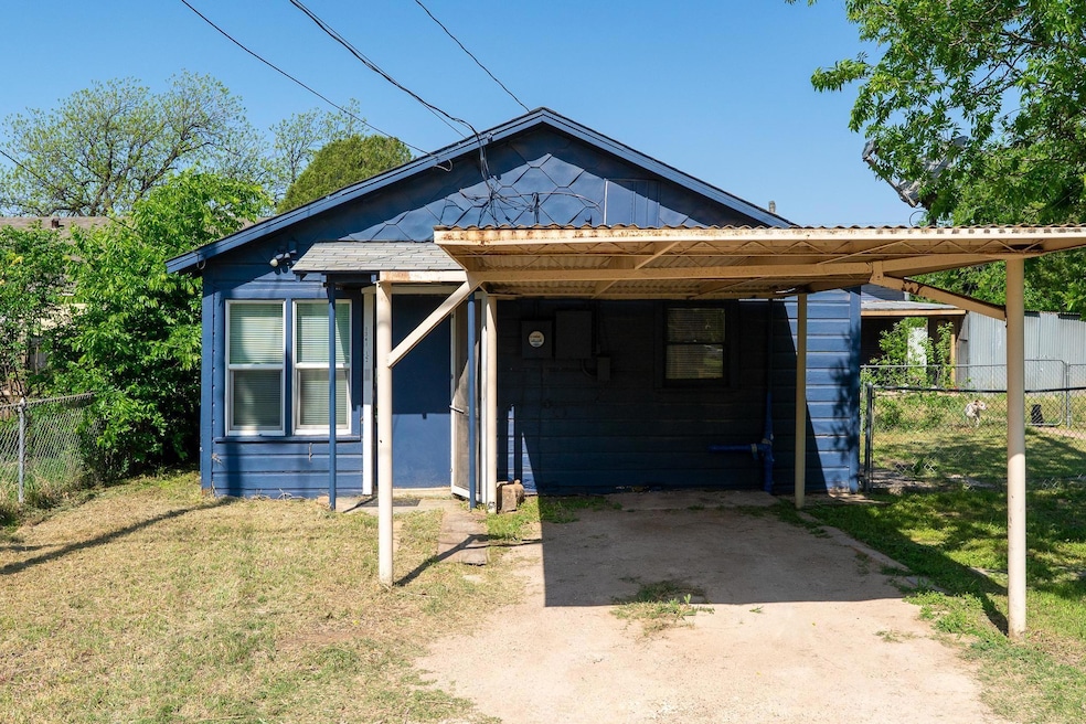 View of front facade with a carport, a front lawn,