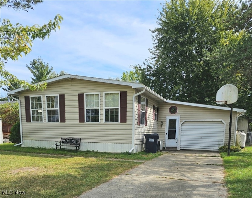 View of front of home with a front yard and a garage