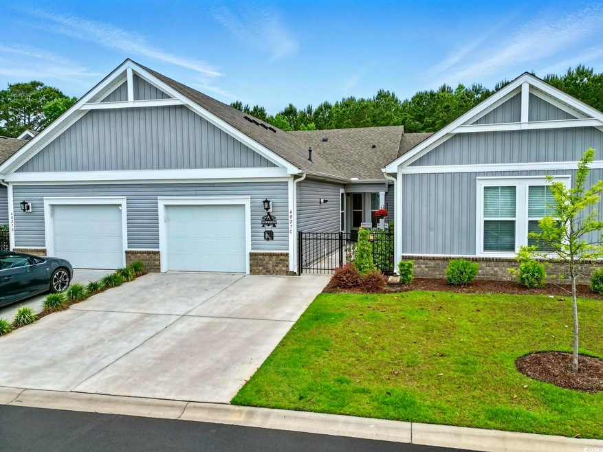 View of front of property with a front yard, board