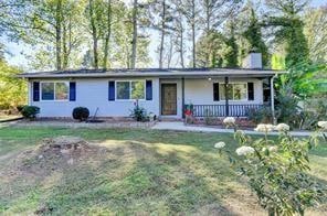 Single story home featuring a porch, a front lawn,