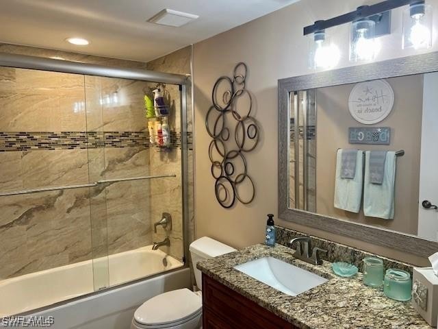Bathroom with combined bath / shower with glass door, vanity, and recessed lighting