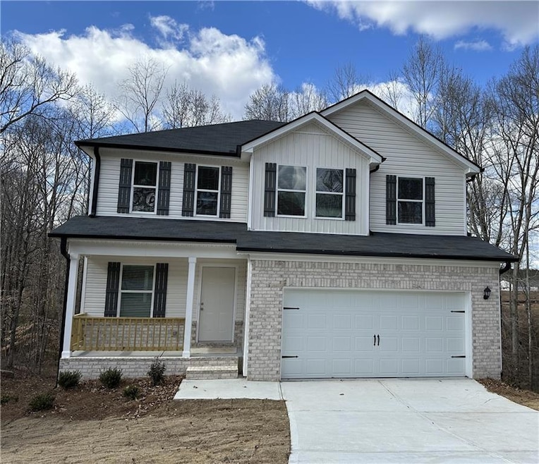 View of front facade featuring a porch, concrete driveway, a garage, and brick siding