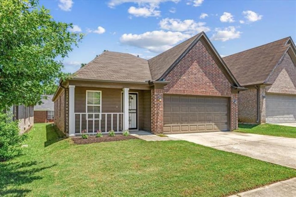View of front facade featuring brick siding, a garage, driveway, and a front lawn