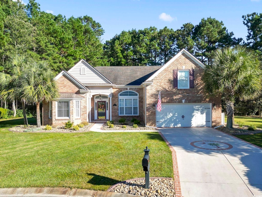 View of front facade featuring brick siding, a front lawn, and concrete driveway