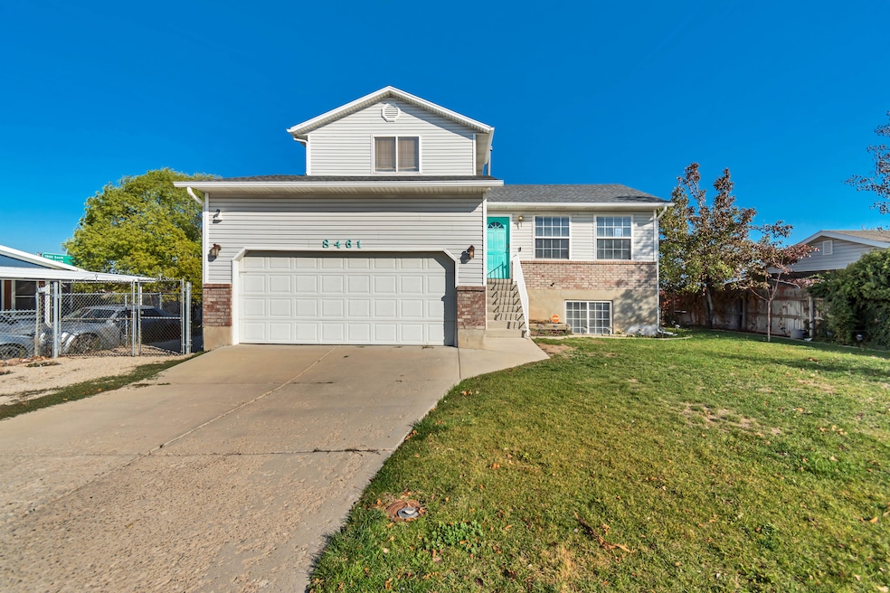 View of front facade with brick siding, concrete driveway, a garage, and a gate
