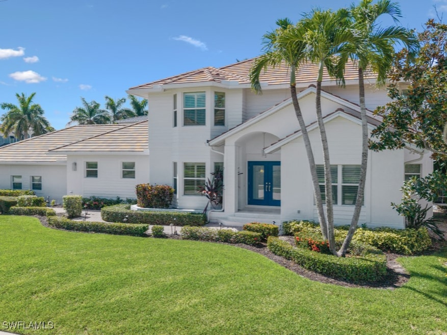 Rear view of property with a yard, french doors, a