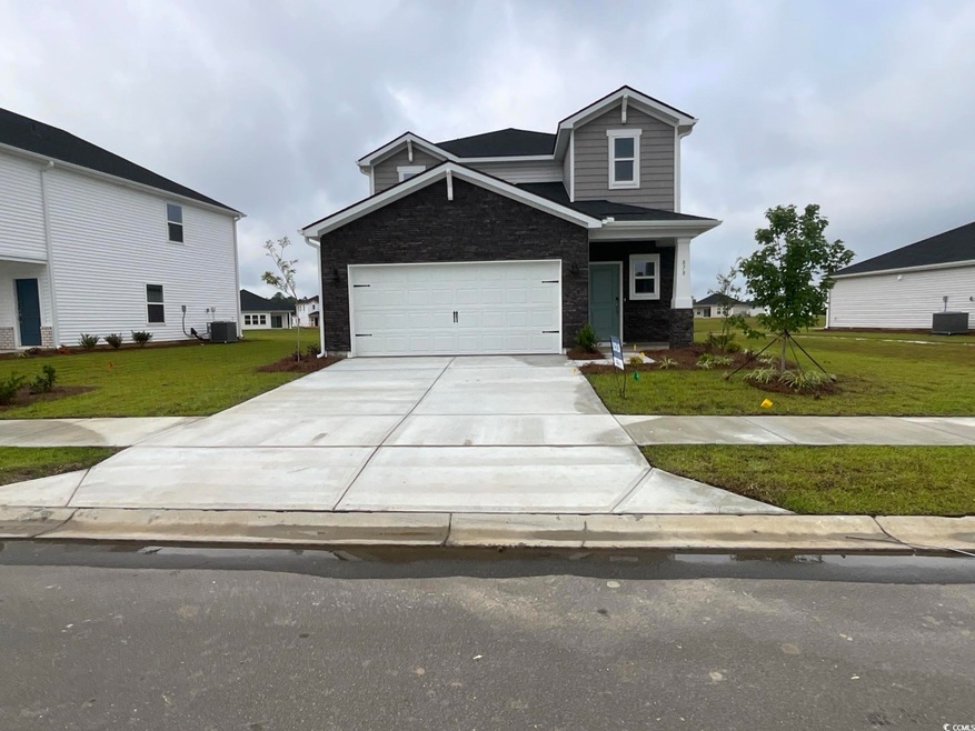 View of front of house featuring concrete driveway, a front lawn, central AC unit, and stone siding