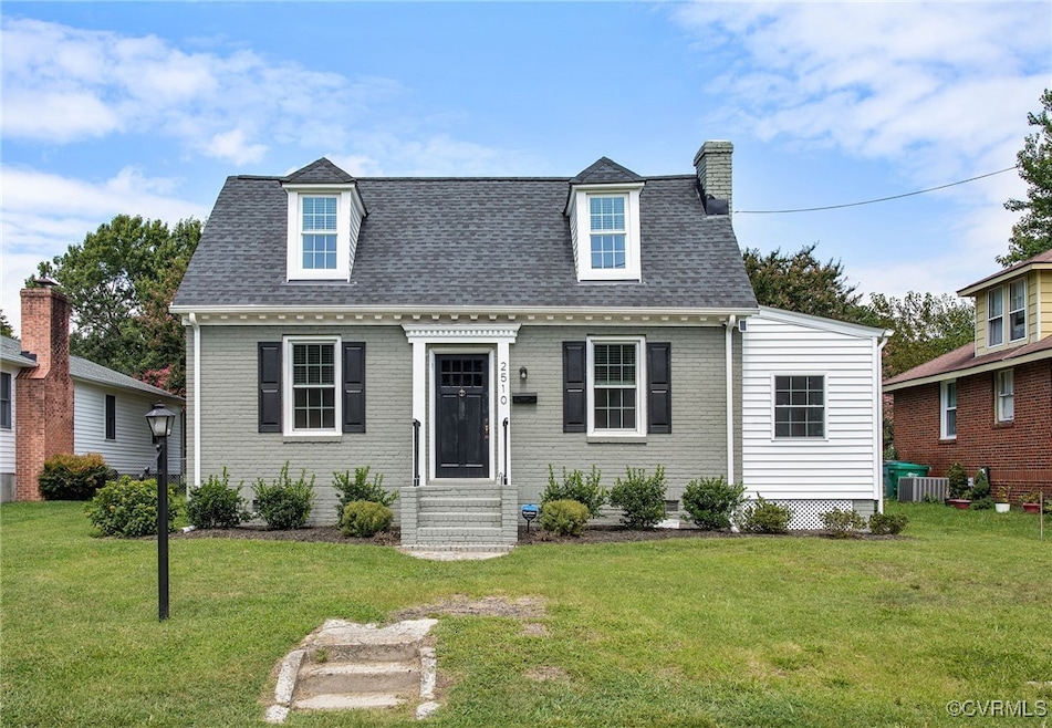 Cape cod house with a front lawn and central AC