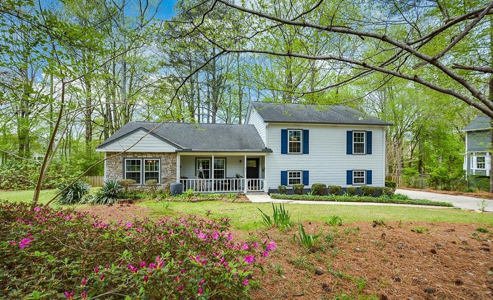 Tri-level home featuring a front lawn and covered 
