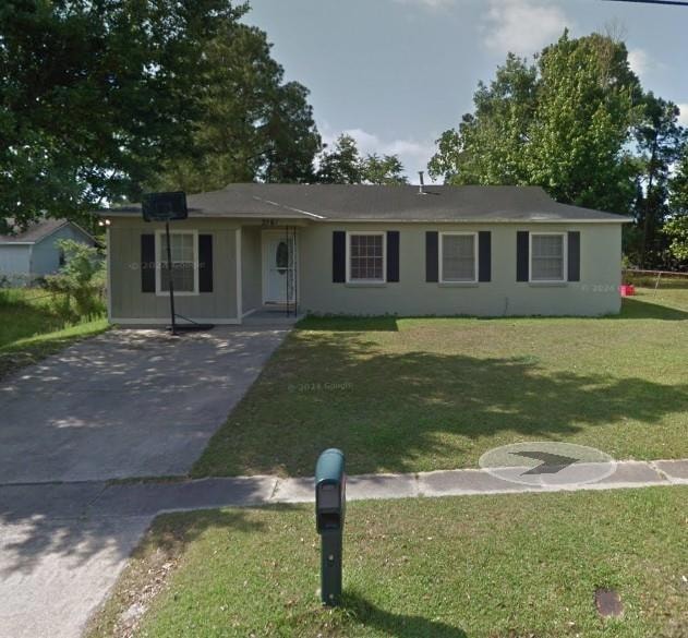 Ranch-style home with a front yard and driveway