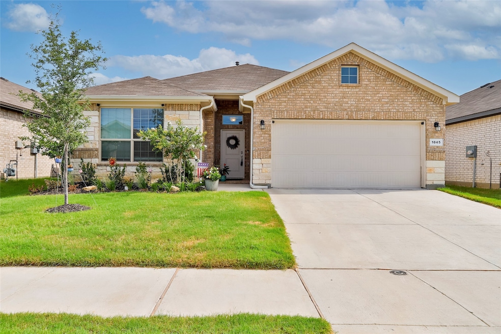Ranch-style house with a front lawn, brick siding, driveway, a garage, and roof with shingles