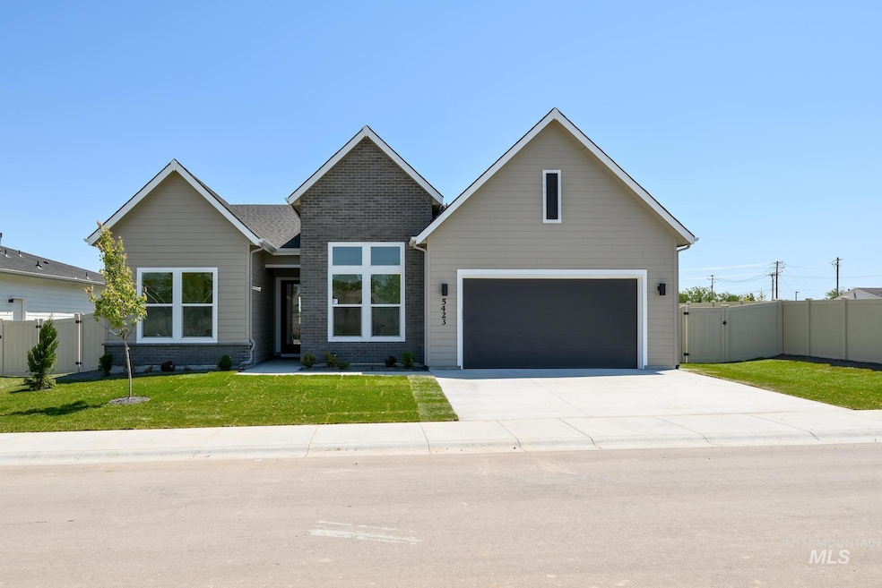 View of front facade featuring driveway, brick siding, and an attached garage