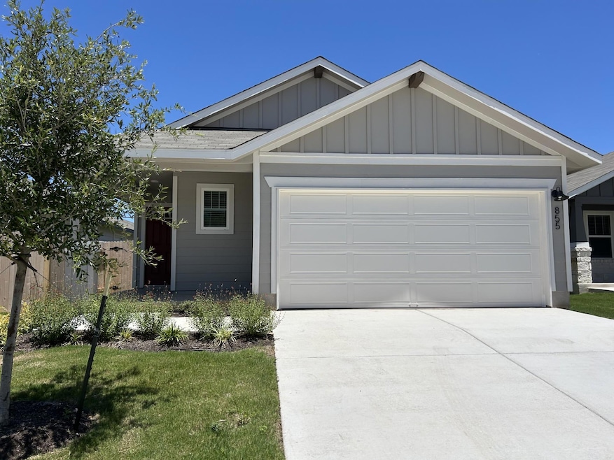 View of front of house featuring board and batten siding, concrete driveway, a garage, and a front yard