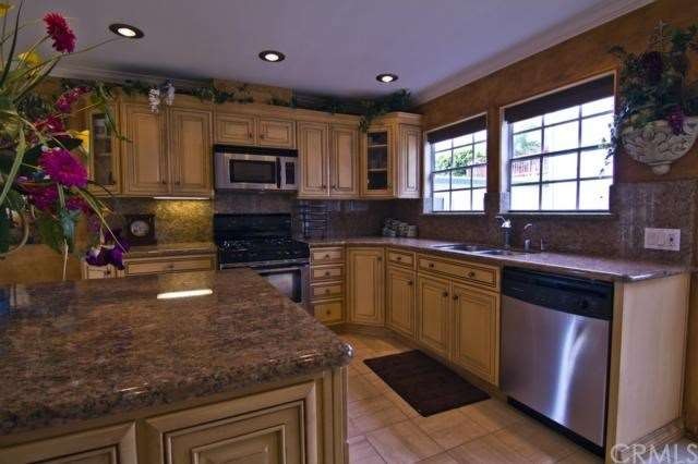Remodeled kitchen with granite counters and traver