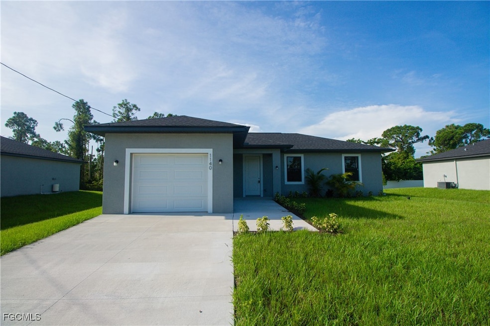 View of front of property with a front yard, an attached garage, driveway, and stucco siding