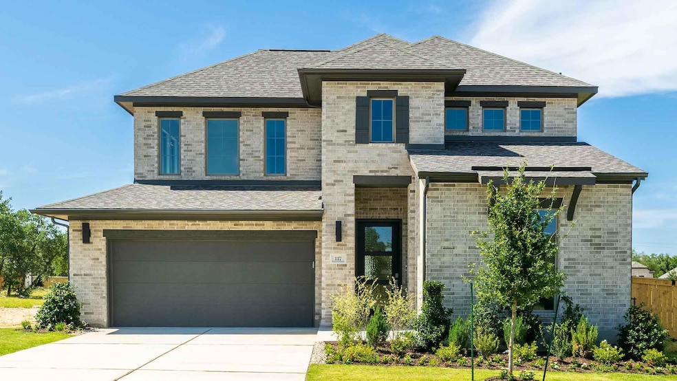 View of front of property featuring a garage, bri