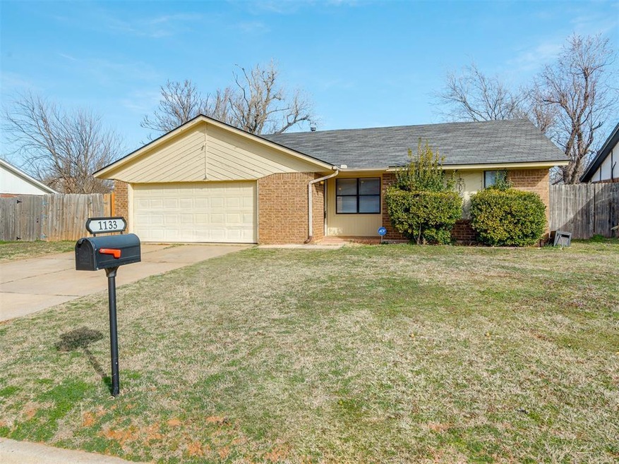 Single story home with a front yard and a garage