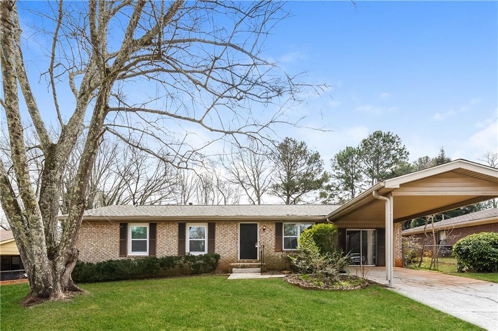 Ranch-style home with a front lawn and a carport