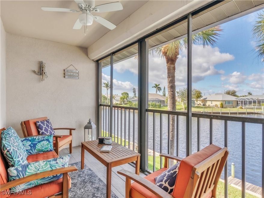 Balcony featuring ceiling fan and a water view