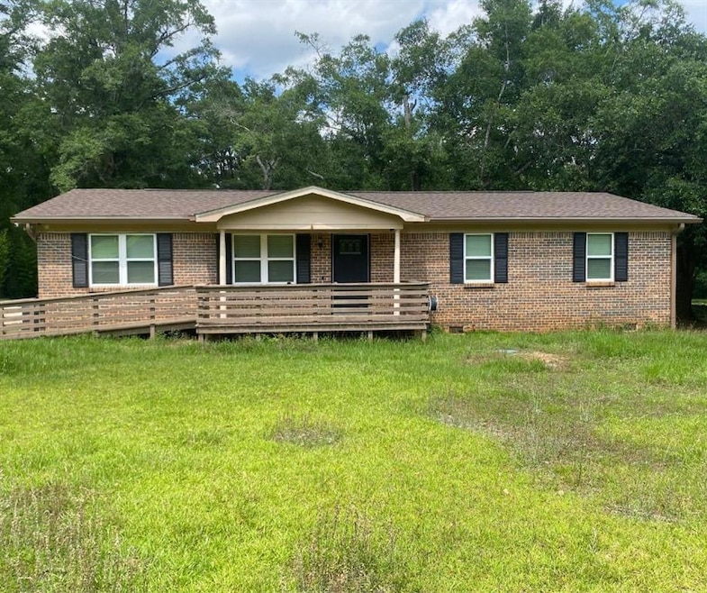 Single story home featuring brick siding, a porch, crawl space, and view of scattered trees