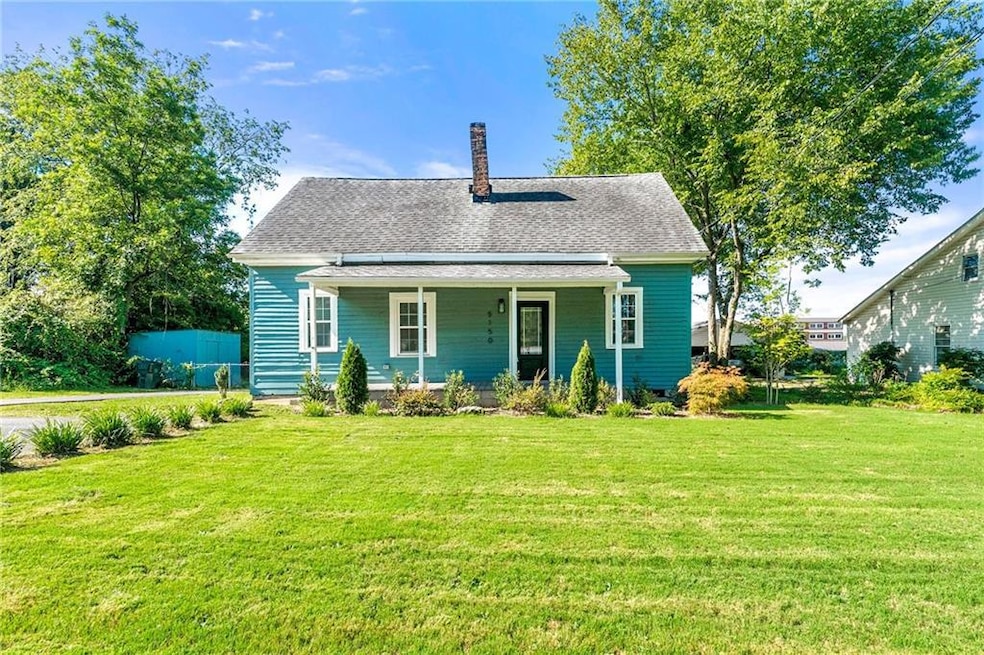 Bungalow-style house featuring a front yard, a porch, a chimney, and a shingled roof