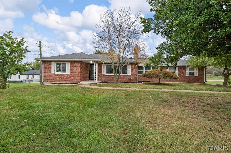 Ranch-style home featuring a front lawn and brick siding