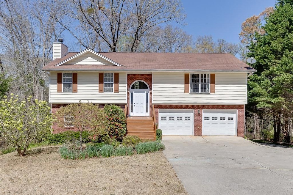 Bi-level home featuring a chimney, a garage, brick