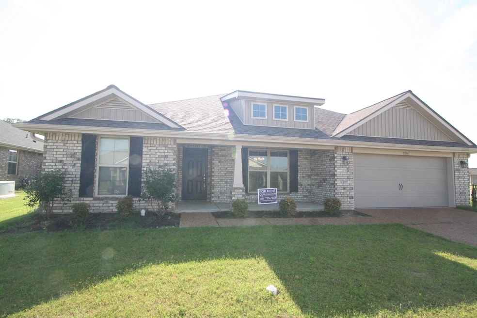 View of front facade featuring an attached garage, a front yard, driveway, and brick siding
