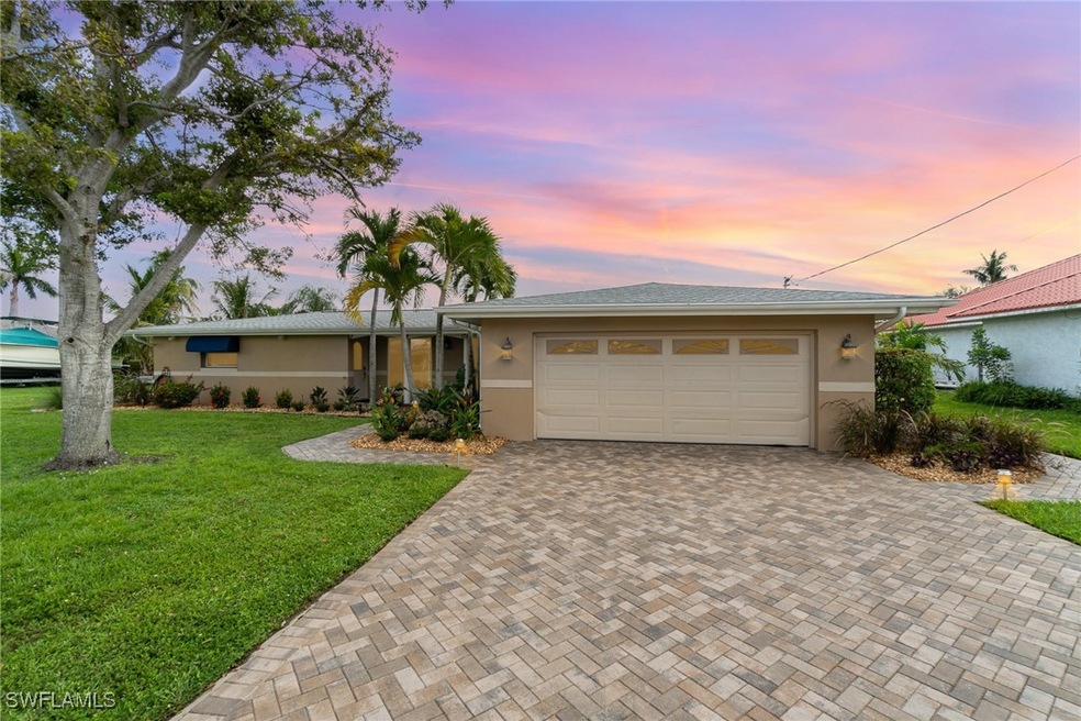 Single story home with a garage and a lawn