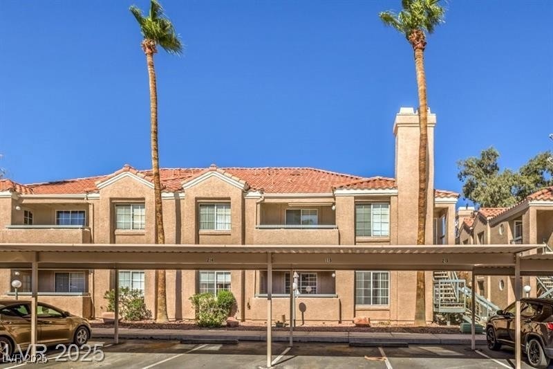 View of building exterior featuring covered parking