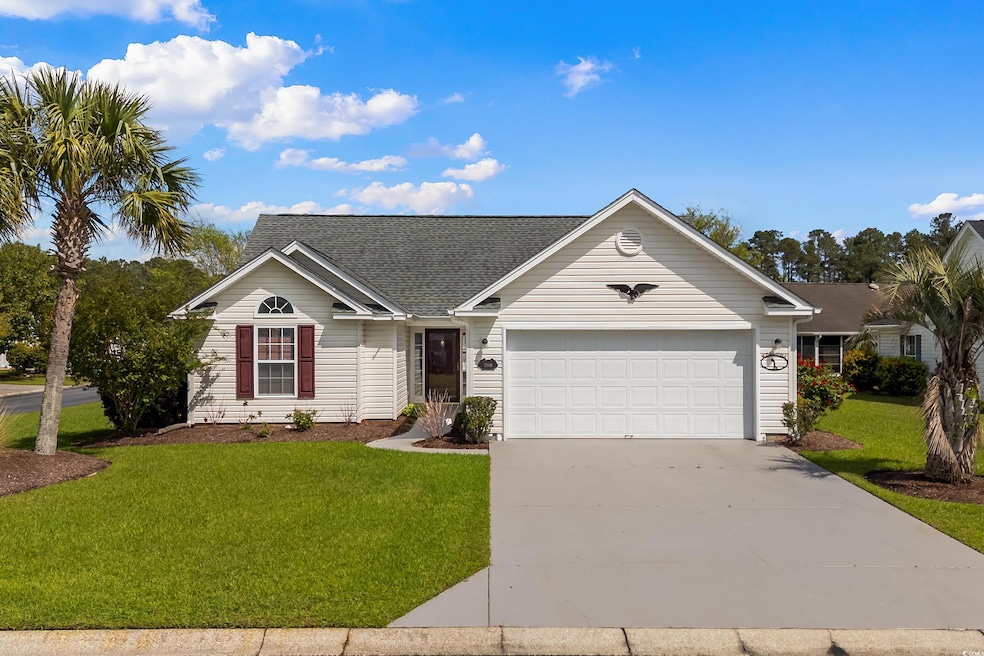 Ranch-style home featuring a front yard, a shingled roof, a garage, and concrete driveway