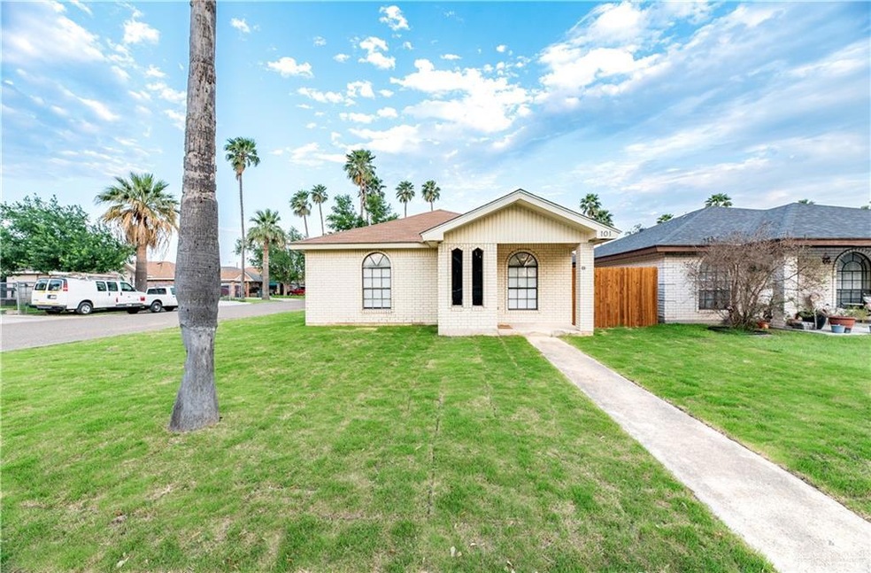 Brick one story home with large yard and side entry carport and driveway.