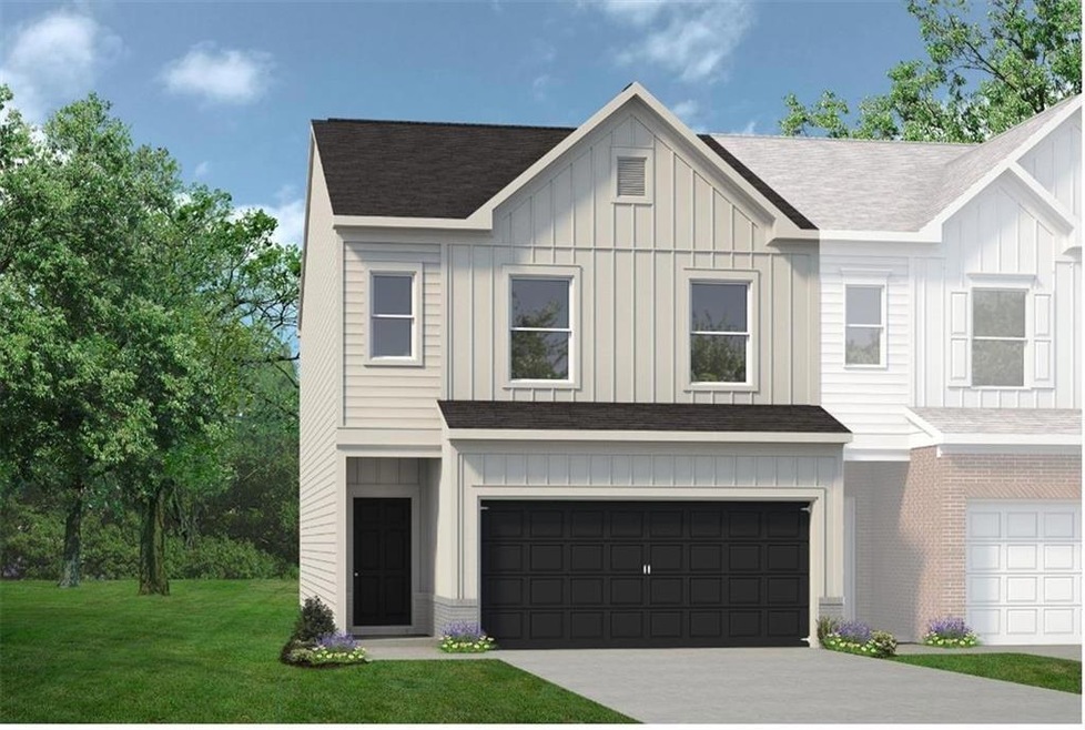 View of front of home with a garage and a front ya