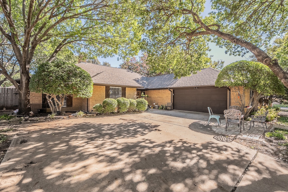 View of front of house with roof with shingles, driveway, a garage, and brick siding