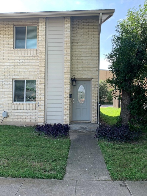 View of exterior entry featuring a lawn and brick